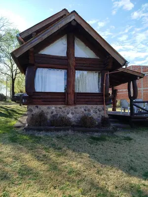 a small cabin with a window in a yard at Cabañas Fénix de Los Reartes in Los Reartes