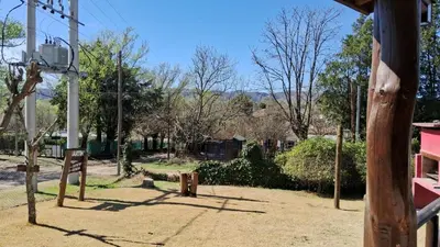 a playground with trees and a wooden pole at Cabañas Fénix de Los Reartes in Los Reartes