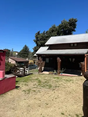 a barn with a metal roof on a field at Cabañas Fénix de Los Reartes in Los Reartes