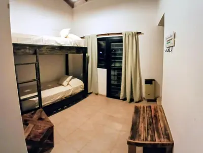 a room with two bunk beds and a wooden bench at Alojamiento ideal en zona norte de Córdoba Capital in Cordoba