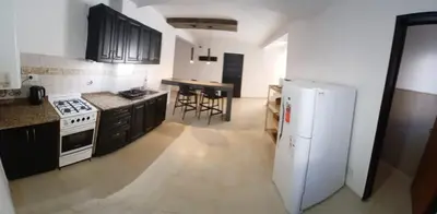 a kitchen with a white refrigerator and a table at Alojamiento ideal en zona norte de Córdoba Capital in Cordoba
