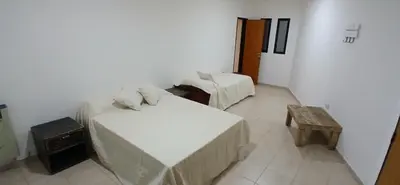 a room with two beds and a table in it at Alojamiento ideal en zona norte de Córdoba Capital in Cordoba