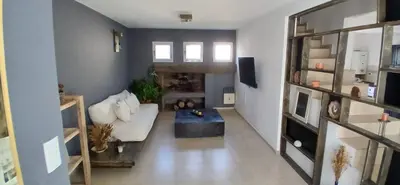 a living room with a white couch and a table at Alojamiento ideal en zona norte de Córdoba Capital in Cordoba