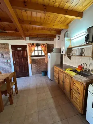 a kitchen with a sink and a refrigerator at La Hormiga in Santa Rosa de Calamuchita