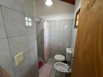 a small bathroom with a toilet and a shower at La Hormiga in Santa Rosa de Calamuchita