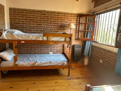 a room with two bunk beds and a brick wall at La Hormiga in Santa Rosa de Calamuchita