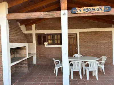 a patio with a table and chairs on a brick building at La Hormiga in Santa Rosa de Calamuchita