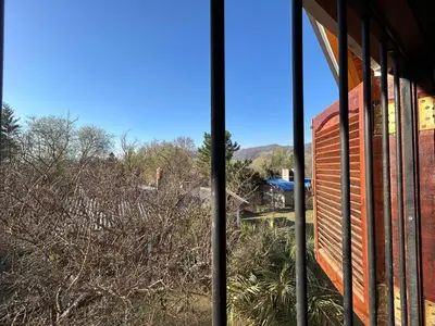 a window of a building with a view of trees at La Hormiga in Santa Rosa de Calamuchita