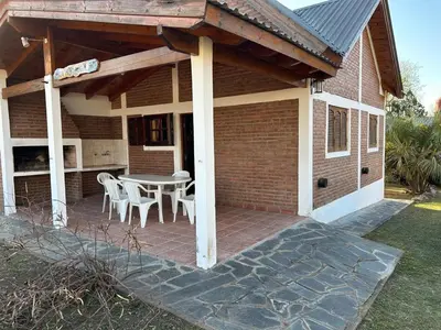 a patio with a table and chairs on a house at La Hormiga in Santa Rosa de Calamuchita