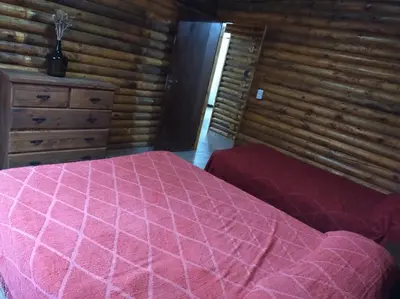a bedroom with a pink bed in a log cabin at La Casa De Mi Viejo in San Javier