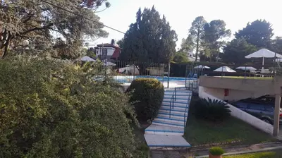 a swimming pool with stairs next to a house at Dpto 22 in Villa Carlos Paz