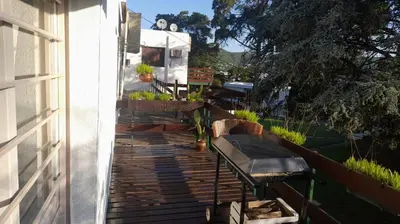 a deck with a bench on the side of a house at Dpto 22 in Villa Carlos Paz