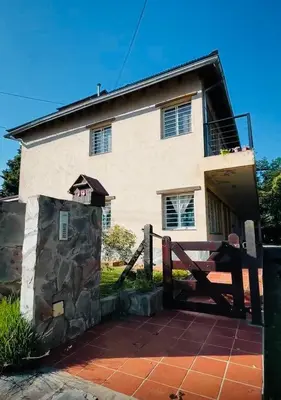 a house with a gate in front of it at Dpto céntrico VGB in Villa General Belgrano