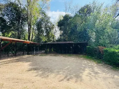 a dirt yard with a fence and a building at Dpto céntrico VGB in Villa General Belgrano