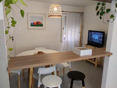 a dining room table with white chairs and a television at Great Lofty in Cordoba
