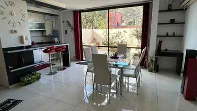 a kitchen and dining room with a glass table and chairs at Departamento Libertad in Villa Carlos Paz