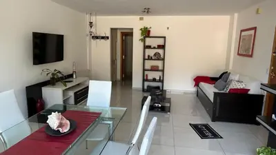 a living room with a glass table and a couch at Departamento Libertad in Villa Carlos Paz