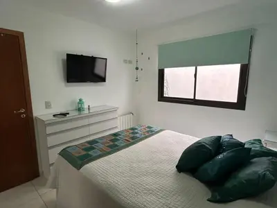 a bedroom with a bed with a television on the wall at Departamento Libertad in Villa Carlos Paz
