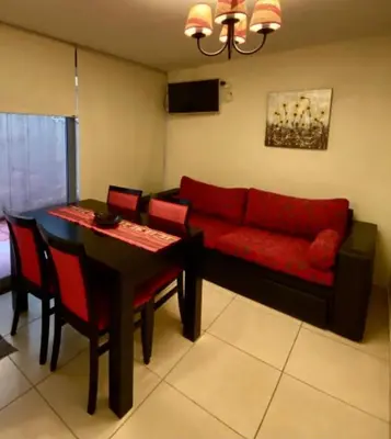 a living room with a red couch and a table at Departamento Centrico Eutico in Villa Carlos Paz