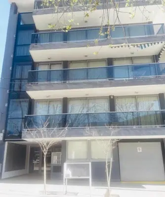 a tall building with a balcony on the side of it at Departamento Centrico Eutico in Villa Carlos Paz