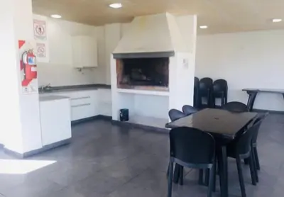 a room with a table and chairs and a fireplace at Departamento Centrico Eutico in Villa Carlos Paz
