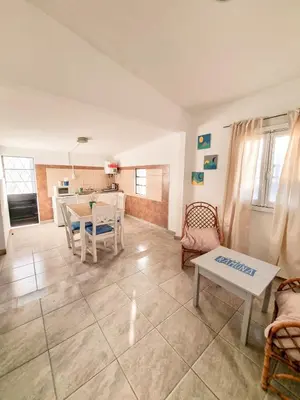 a living room with a table and a kitchen at Casa Ramona in Embalse