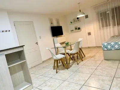 a kitchen and dining room with a table and chairs at Urban Alberdi Dpto con cochera, pileta y seguridad 24 hs in Cordoba