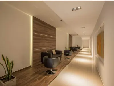 a waiting room with a row of chairs and a long corridor at Urban Alberdi Dpto con cochera, pileta y seguridad 24 hs in Cordoba