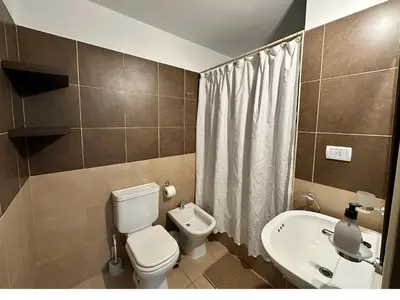 a small bathroom with a toilet and a sink at Urban Alberdi Dpto con cochera, pileta y seguridad 24 hs in Cordoba