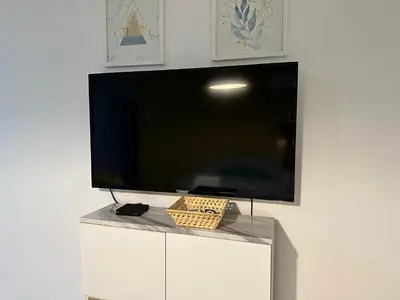 a flat screen tv sitting on top of a white cabinet at Urban Alberdi Dpto con cochera, pileta y seguridad 24 hs in Cordoba