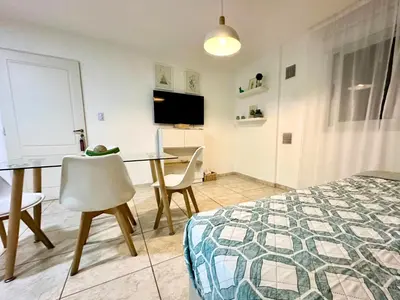 a bedroom with a bed and a table and a desk at Urban Alberdi Dpto con cochera, pileta y seguridad 24 hs in Cordoba