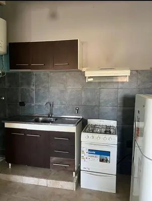 a kitchen with a sink and a stove top oven at Villa Dolores - Departamento
