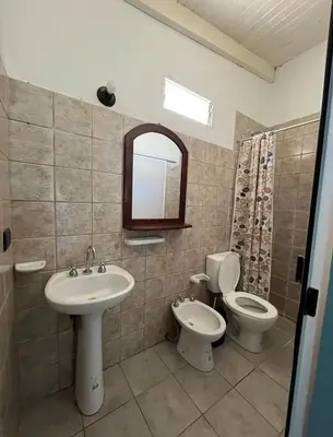 a bathroom with a sink and a toilet and a mirror at Villa Dolores - Departamento