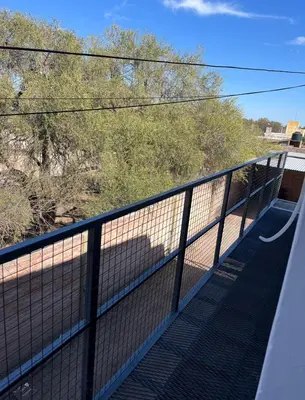 a fence on a bridge with a view of trees at Villa Dolores - Departamento