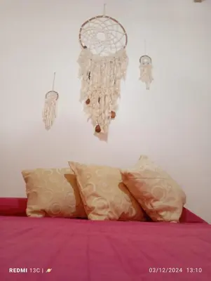 a bedroom with a bed with pink sheets and a chandelier at Cabañas KAIZEN in Santa María
