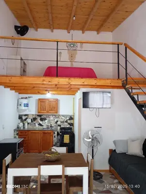 a living room with a table and a loft at Cabañas KAIZEN in Santa María