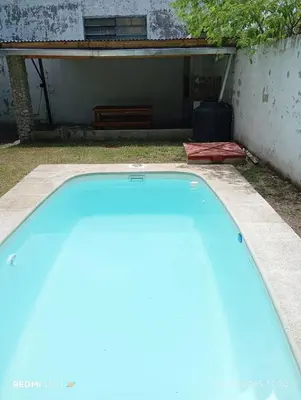 a blue swimming pool in a yard with a bench at Cabañas KAIZEN in Santa María