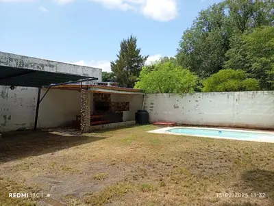 a backyard with a swimming pool and a building at Cabañas KAIZEN in Santa María