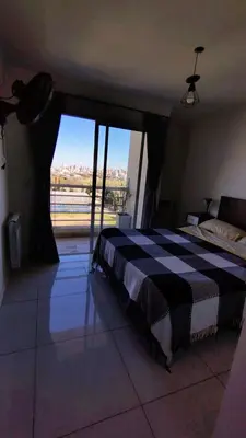 a bedroom with a black and white bed and a window at Departamento Atardecer de Rio Cuarto in Río Cuarto
