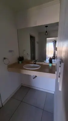 a bathroom with a sink and a large mirror at Departamento Atardecer de Rio Cuarto in Río Cuarto