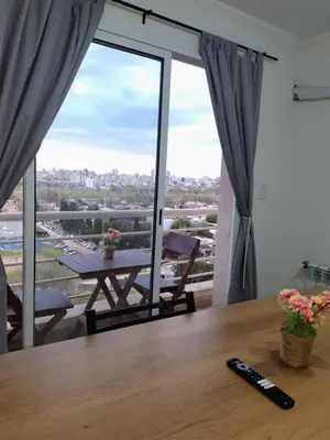 a remote control sitting on a table in front of a window at Departamento Atardecer de Rio Cuarto in Río Cuarto