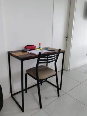 a wooden table with a chair in a room at Departamento Atardecer de Rio Cuarto in Río Cuarto