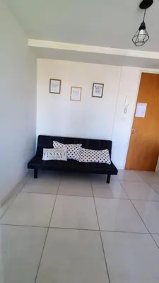 a black couch in a room with a wooden door at Departamento Atardecer de Rio Cuarto in Río Cuarto