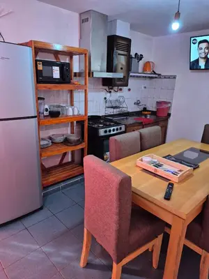 a kitchen with a wooden table with chairs and a refrigerator at Dpto Cordoba in Cordoba
