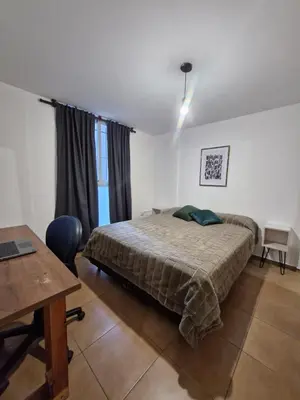 a bedroom with a bed and a table and a desk at Alberdi Urban Suite in Cordoba