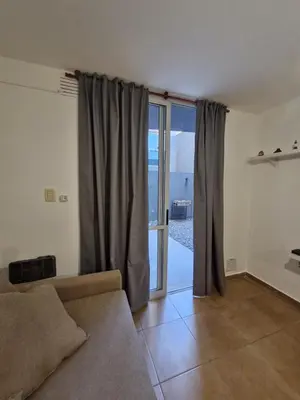 a living room with a couch and a sliding glass door at Alberdi Urban Suite in Cordoba