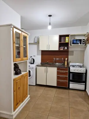 a kitchen with white cabinets and a stove top oven at Alberdi Urban Suite in Cordoba