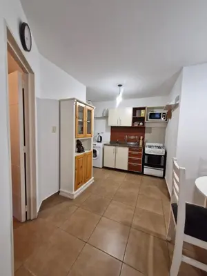 a kitchen with white walls and a large tile floor at Alberdi Urban Suite in Cordoba