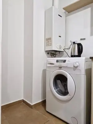 a washing machine in a kitchen with a microwave at Alberdi Urban Suite in Cordoba