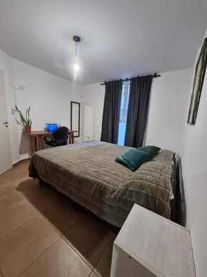 a bedroom with a bed and a desk and a table at Alberdi Urban Suite in Cordoba